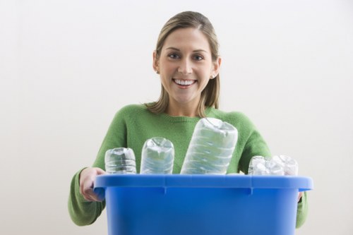 Worker wearing PPE handling waste at a collection point